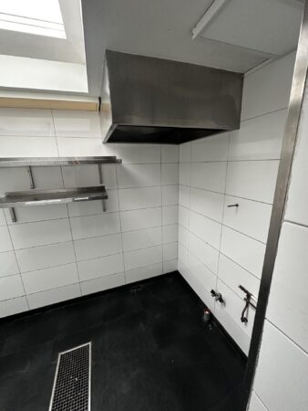 Wit betegelde horecakeuken in aanbouw met afzuigkap, wandrekken en leidingaansluitingen op het Sint-Agathaplein.